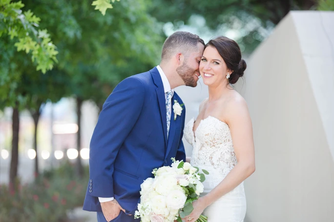 True Bride Bonnie, standing outside with her husband, wearing a Martina Liana wedding dress, style 906.