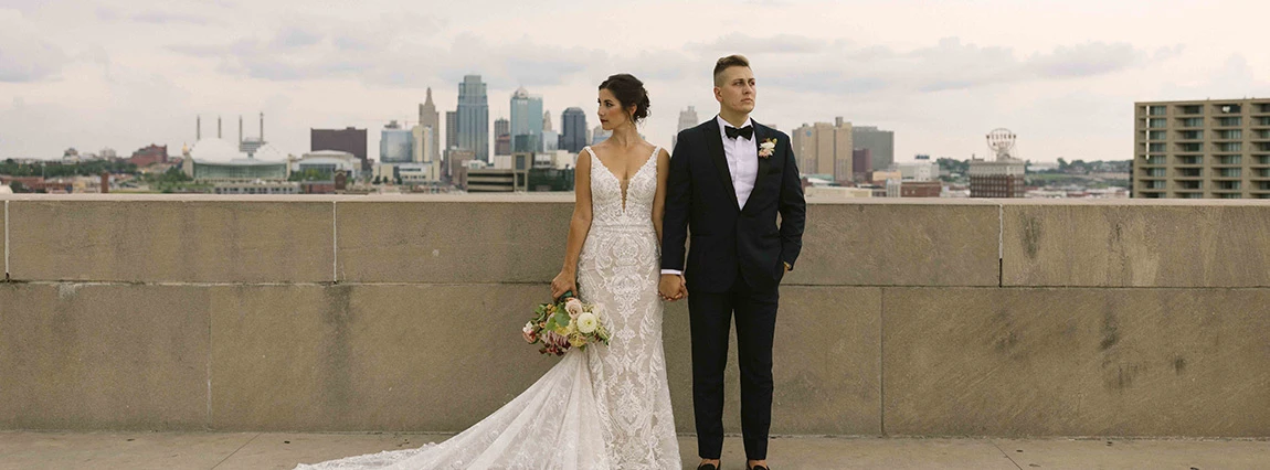 True Society Bride and groom posing in front of the Kansas City skyline
