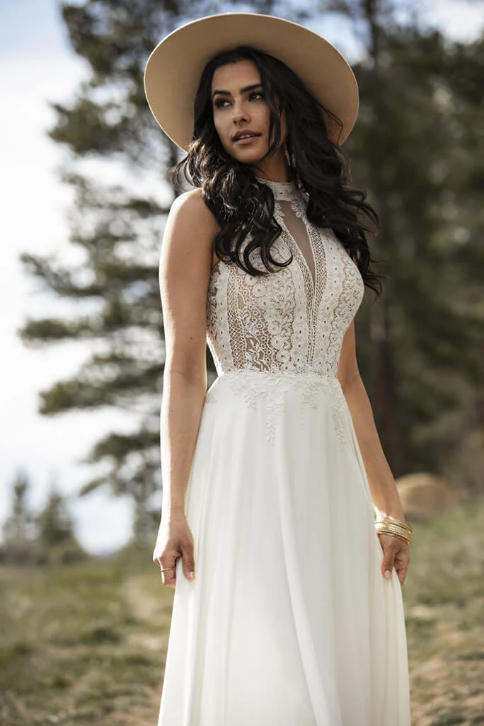 Bride pairing a wide-brimmed hat with her June wedding gown from the All Who Wander wedding gown collection