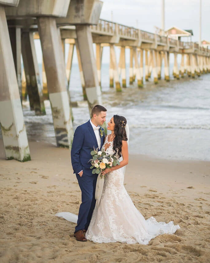 Bride Caroline posing on a beach wearing her Essense of Australia wedding dress, style D2548