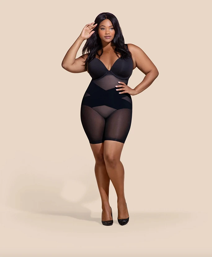Plus size model wearing a black bodysuit which can be worn underneath a bridal gown