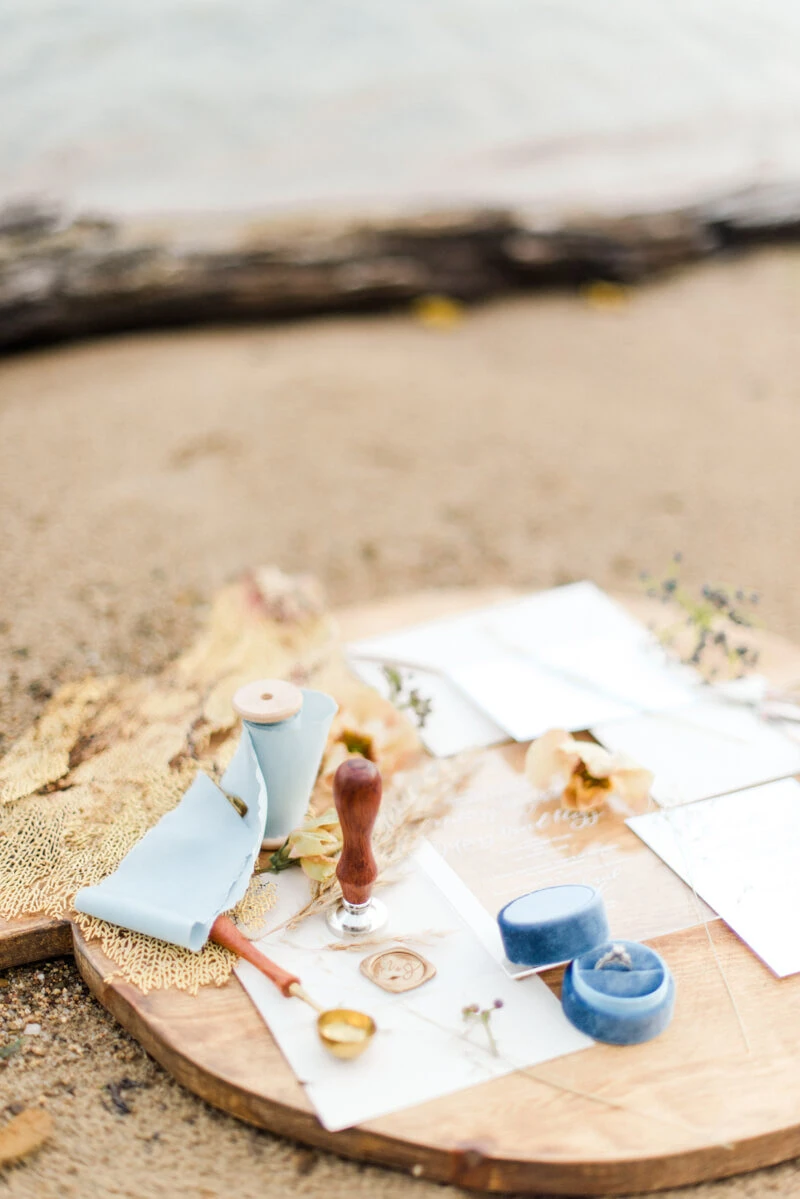 Trendy bride styled photo of wedding invitations with ocean background