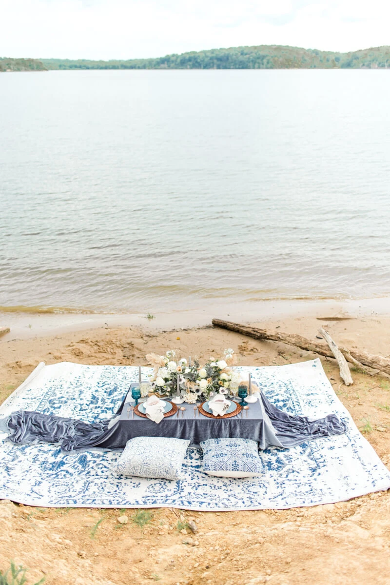 Trendy bride styled photo of table with wedding desserts and ocean background