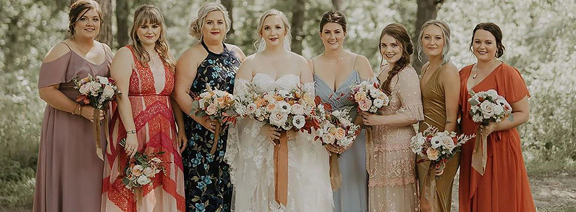 Bride with her bride tribe wearing mixmatched bridesmaid dresses