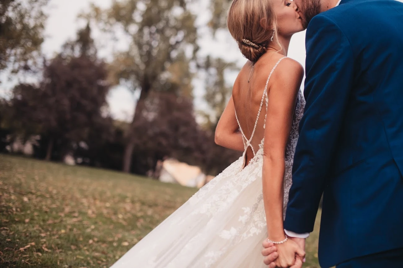 true bride holding her husbands hand and posing for wedding photo