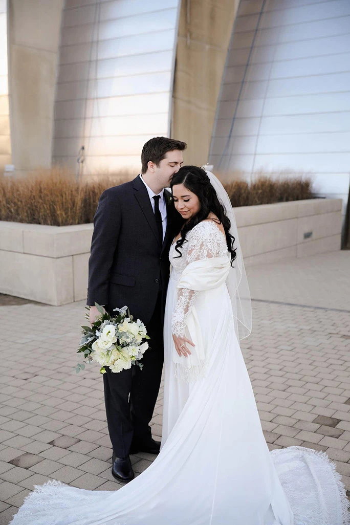 true bride julia posing for wedding photos outside of the Kauffman Performing Arts Center in KC