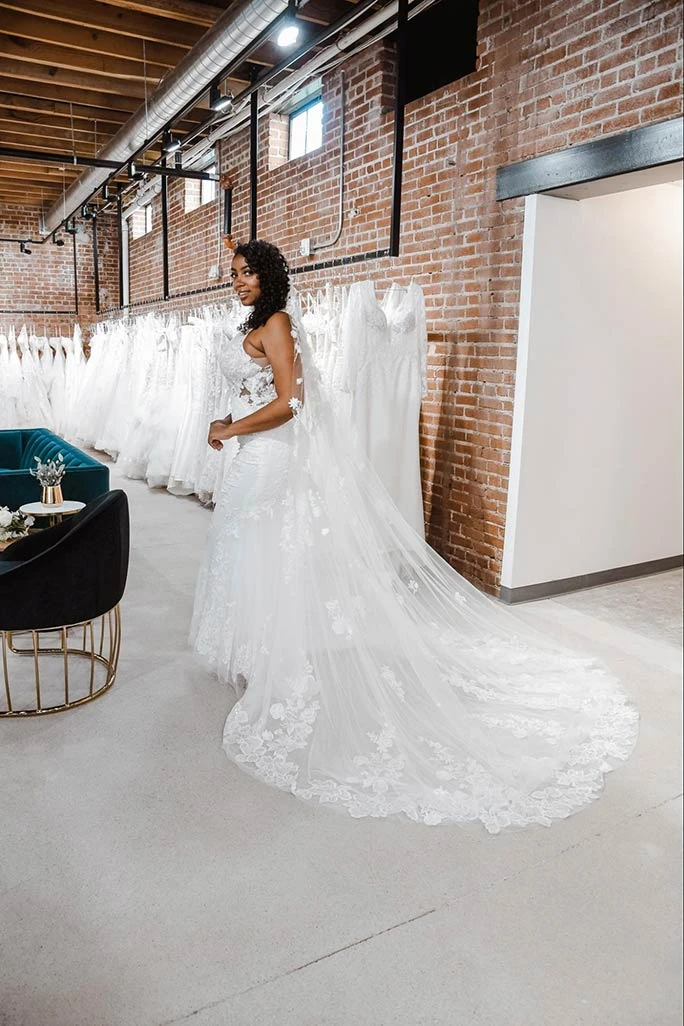 Bride posing with a cathedral length lace veil