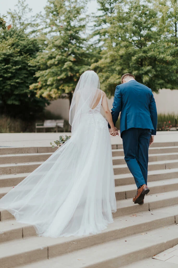 real bride and groom walking up stairs at kauffman center in kansas city - style D2840 by essense of australia