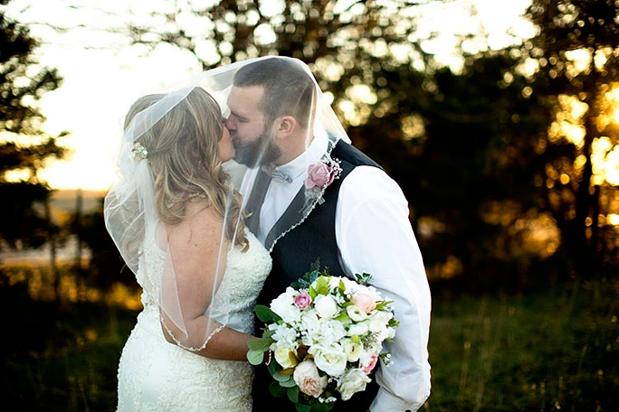 real bride and groom sharing a kiss - style D2174 by essense of Australia