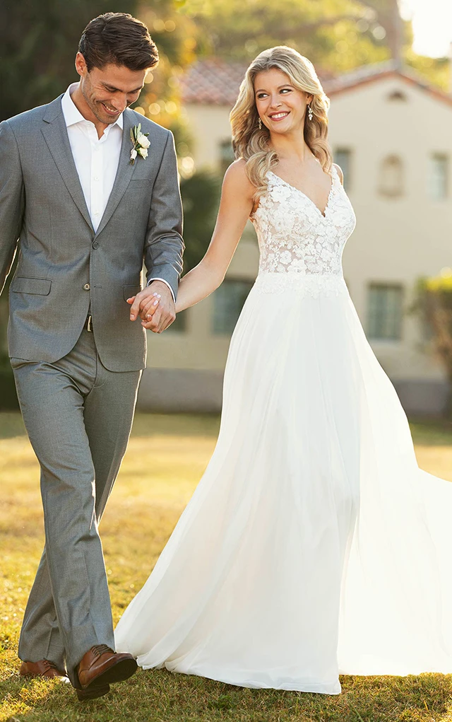 bride and husband walking hand in hand wearing stella york gown 7134