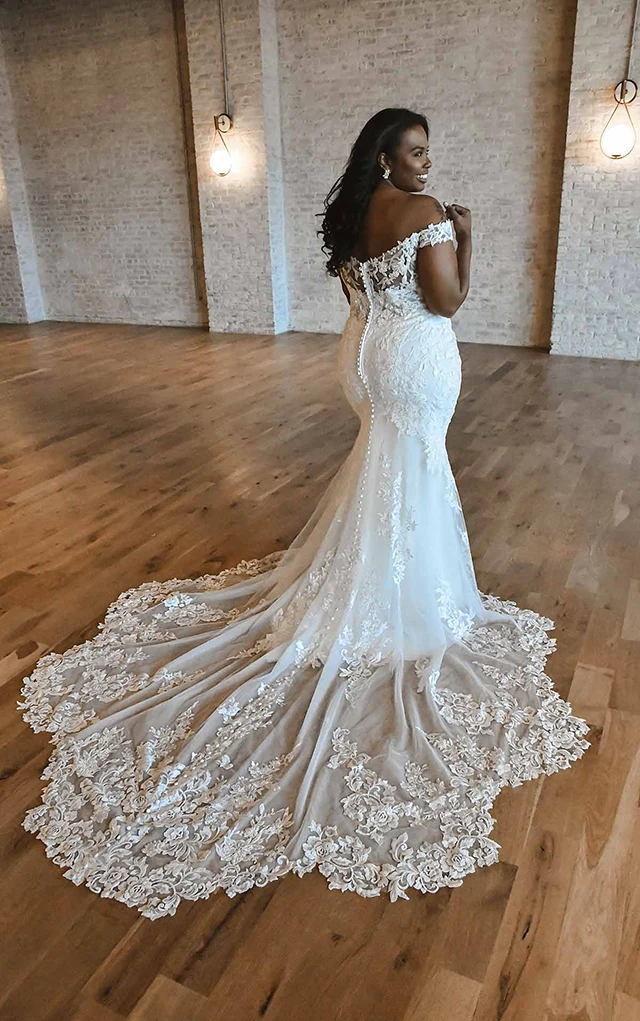 plus size bride shows off back of lace fit and flair gown d3247+ by essense of australia
