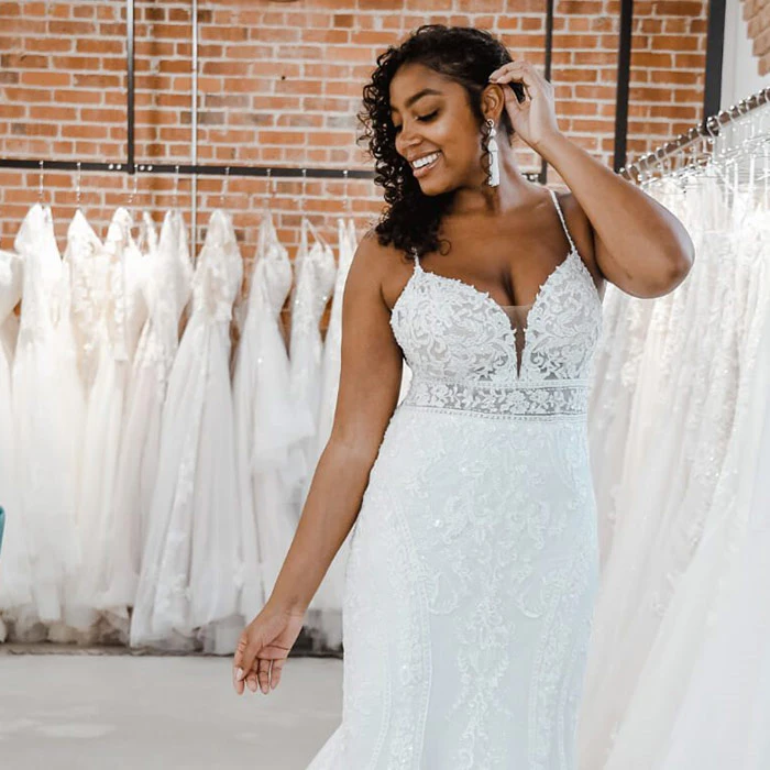Woman of color bride wearing a lace wedding dress.
