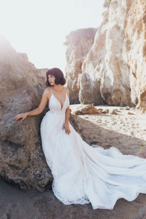True Bride on a rocky beach, wearing a flowy beach wedding dress