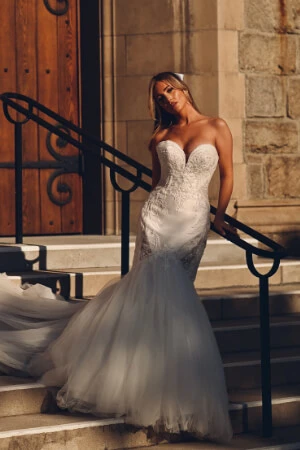 True Bride standing on steps wearing a strapless, sweetheart neckline mermaid wedding dress