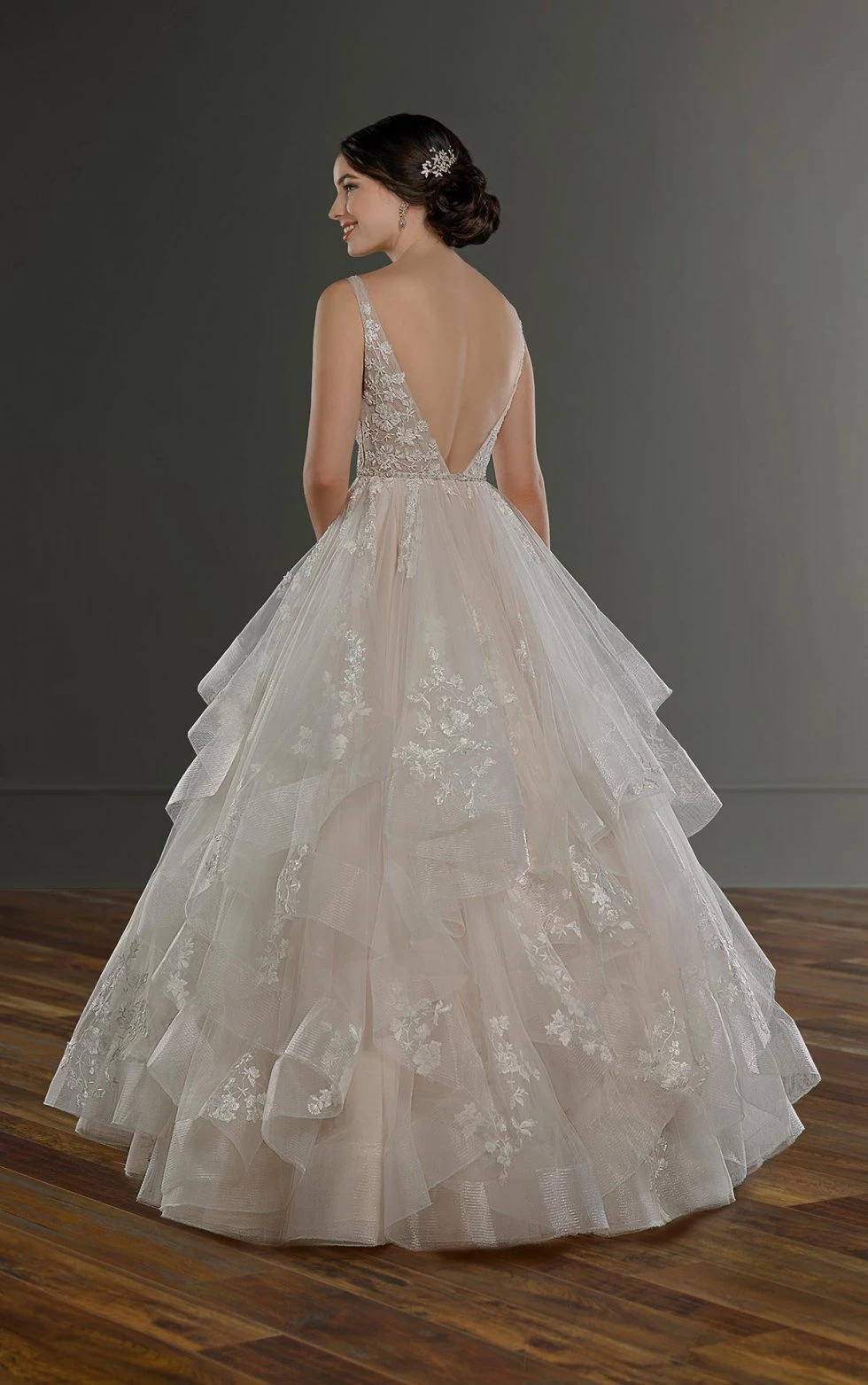 Bride wears open-back princess wedding dress with layered lace and tulle skirt.