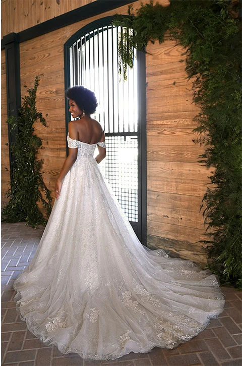 Bride wears romantic lace off-the-shoulder princess wedding dress.