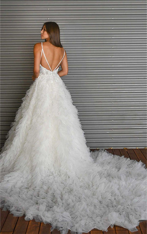 Bride wears princess wedding dress with open back detail and layered tulle skirt.