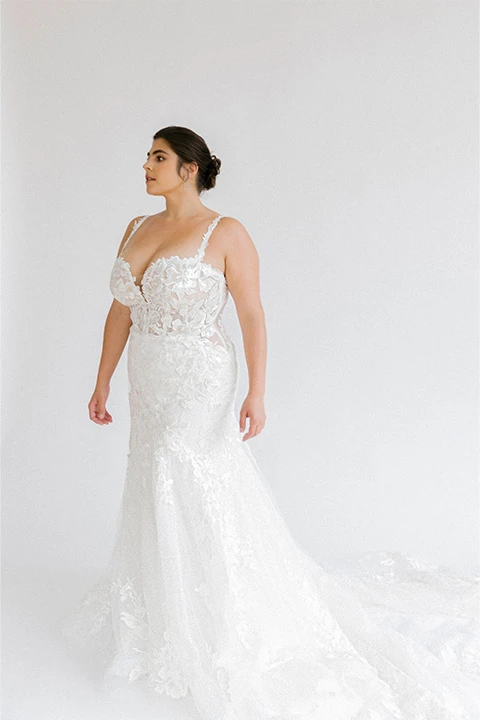 Bride wearing glamourous plus size beach wedding dress with floral