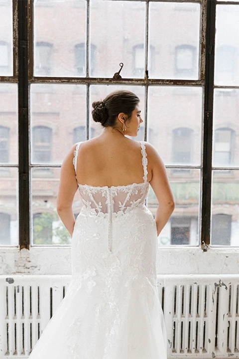 Bride wearing glamourous plus size beach wedding dress with floral