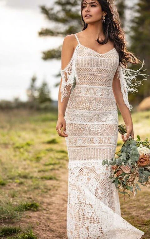Bride wearing bohemian spaghetti strap off-the-shoulder lace wedding gown with fringes