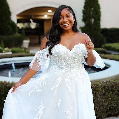 Plus sized bride wearing tulle wedding dress with lace bodice and sleeves