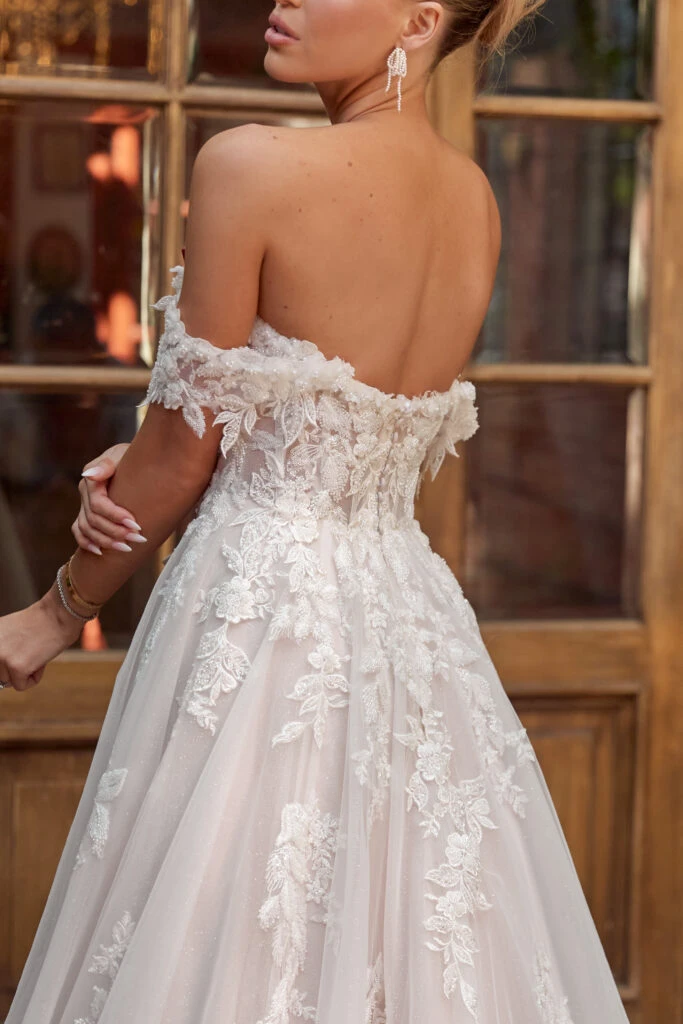 Back of bride wearing an off the shoulder lace wedding dress