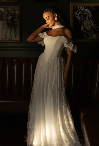 Bride wearing off-the-shoulder lace and crepe a-line wedding dress with detachable sleeves