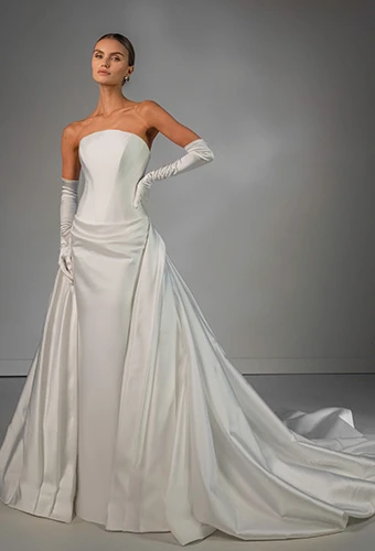Bride wearing strapless satin column wedding dress with overskirt
