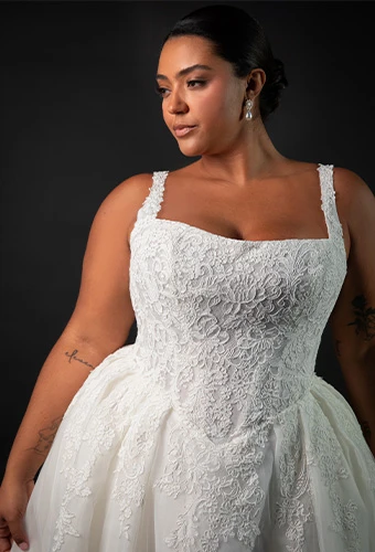 Plus size bride wearing sparkling lace wedding dress with square neckline