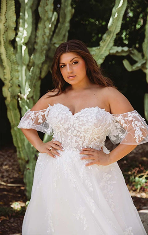 Plus sized bride wearing tulle wedding dress with lace bodice and sleeves