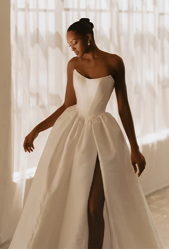 Bride wearing strapless silk ballgown with scoop neckline and high leg slit