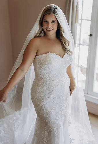 Plus size bride wearing strapless lace wedding dress with sweetheart neckline