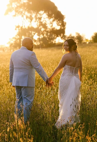 Bride posing with her husband with an American bustle