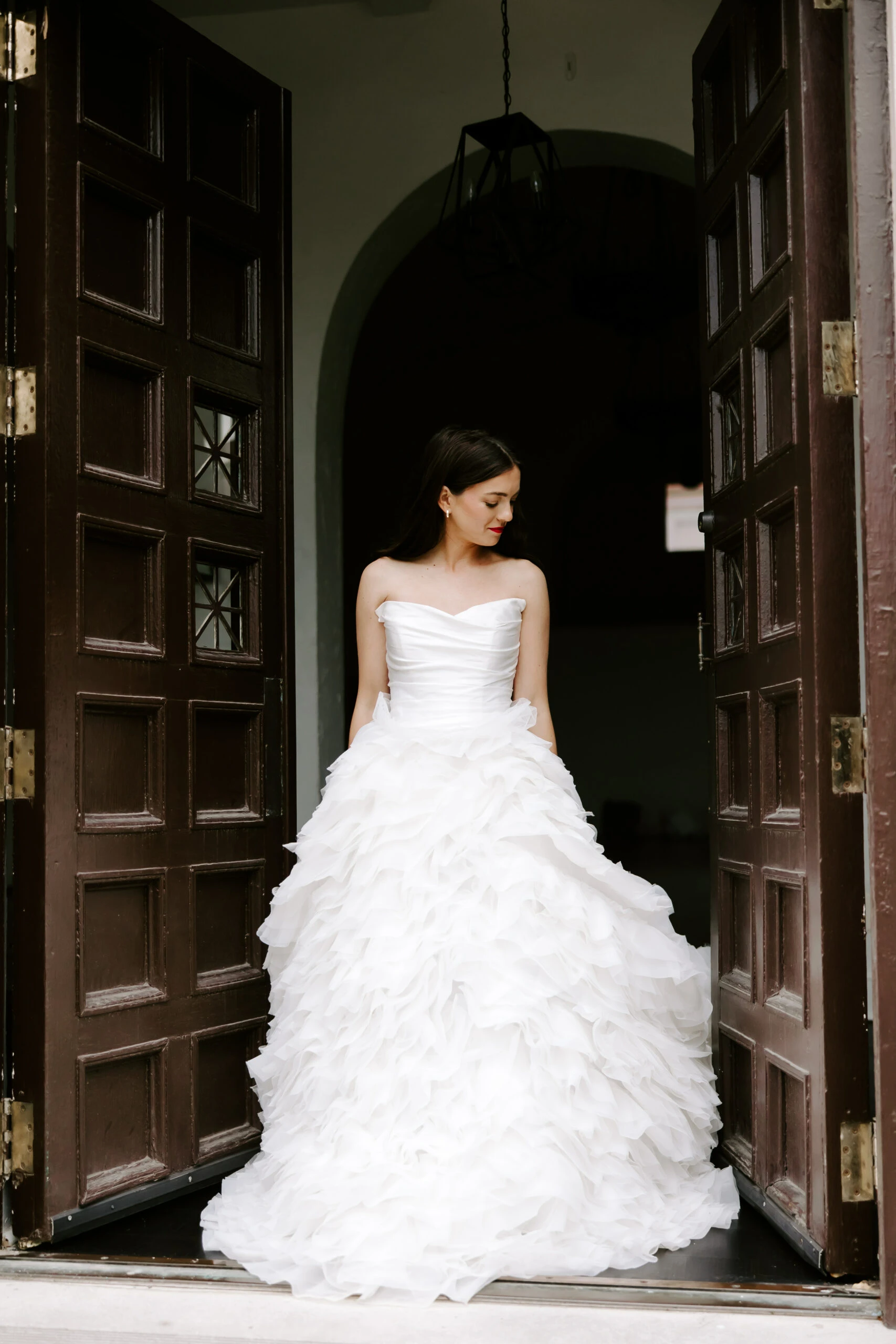 Bride standing in a doorway wearing a tulle ballgown wedding dress