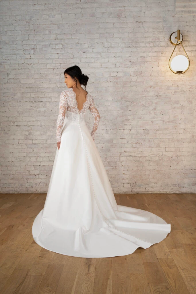Back of bride wearing a long sleeve lace ballgown wedding dress