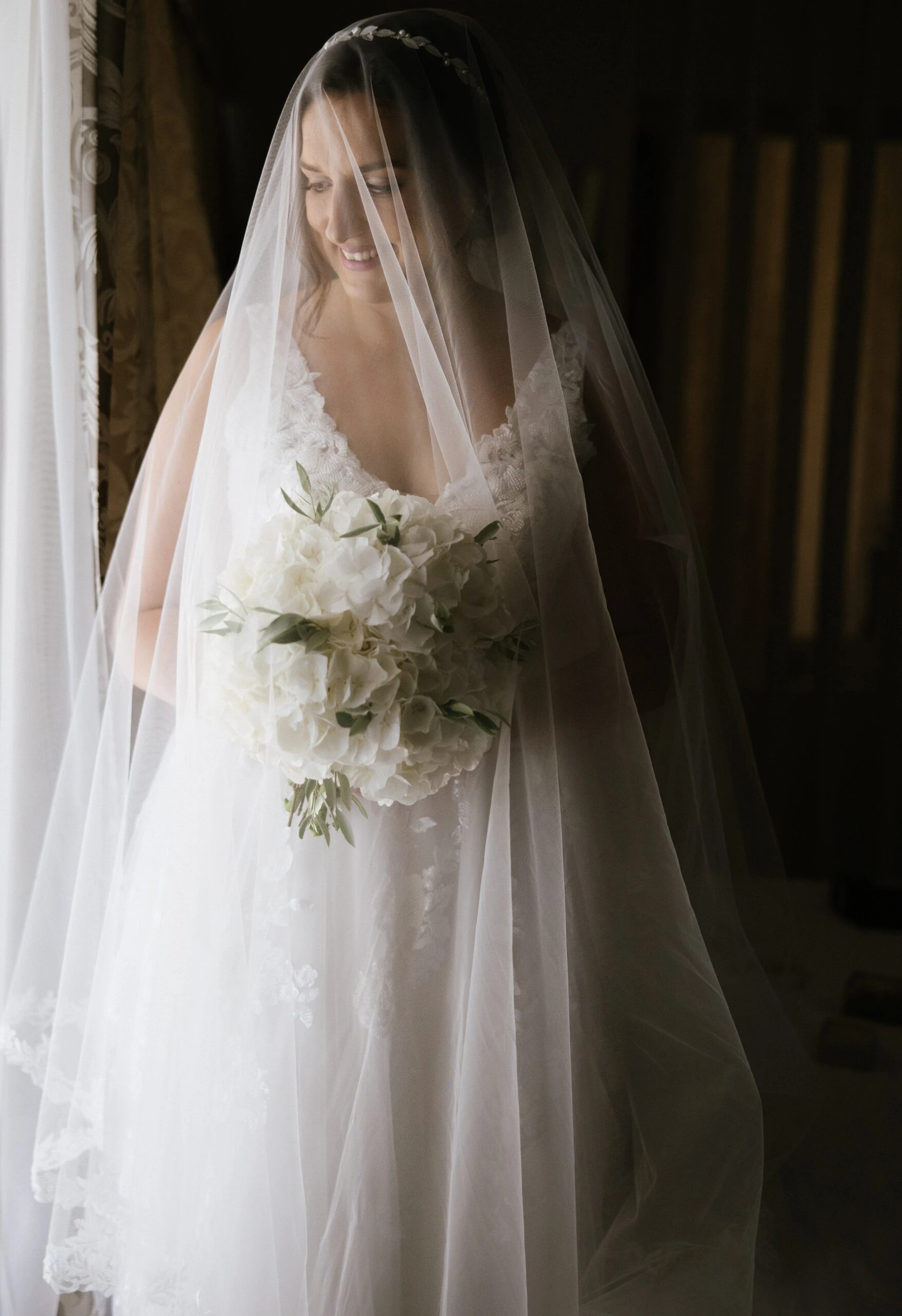 Bride wearing a wedding dress and veil holding flowers