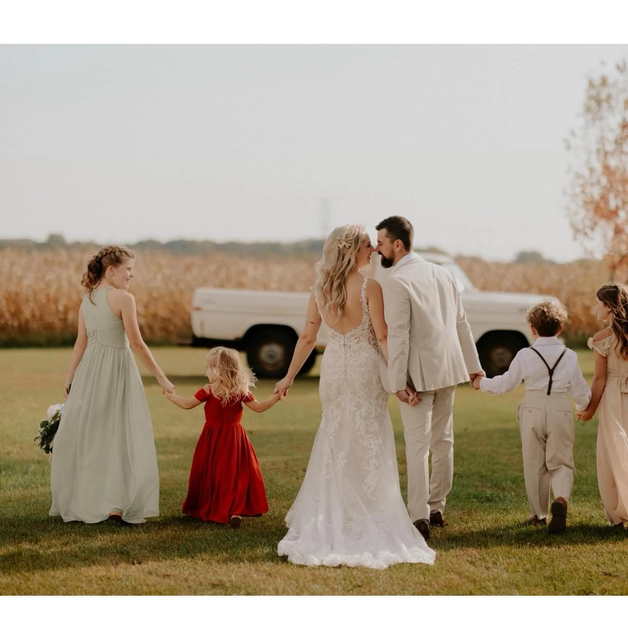 true bride megan holding hands with her family - D2548 by Essense of Australia