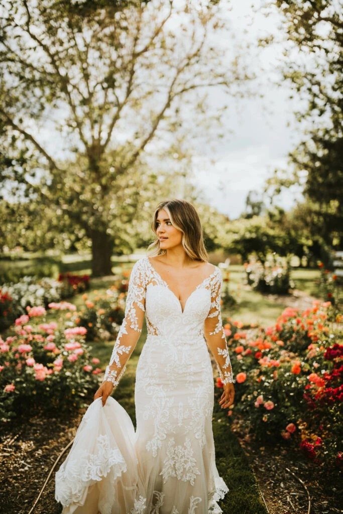 Bride wearing a log sleeve lace trumpet wedding dresses in a garden