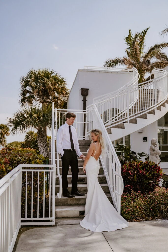 Bride and groom holding hands on a staircase