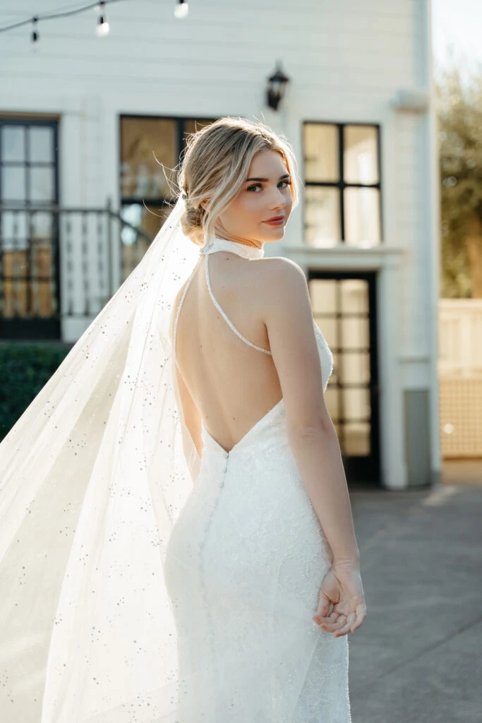 Bride wearing a halter neck beaded ad sequin wedding dress with a low back