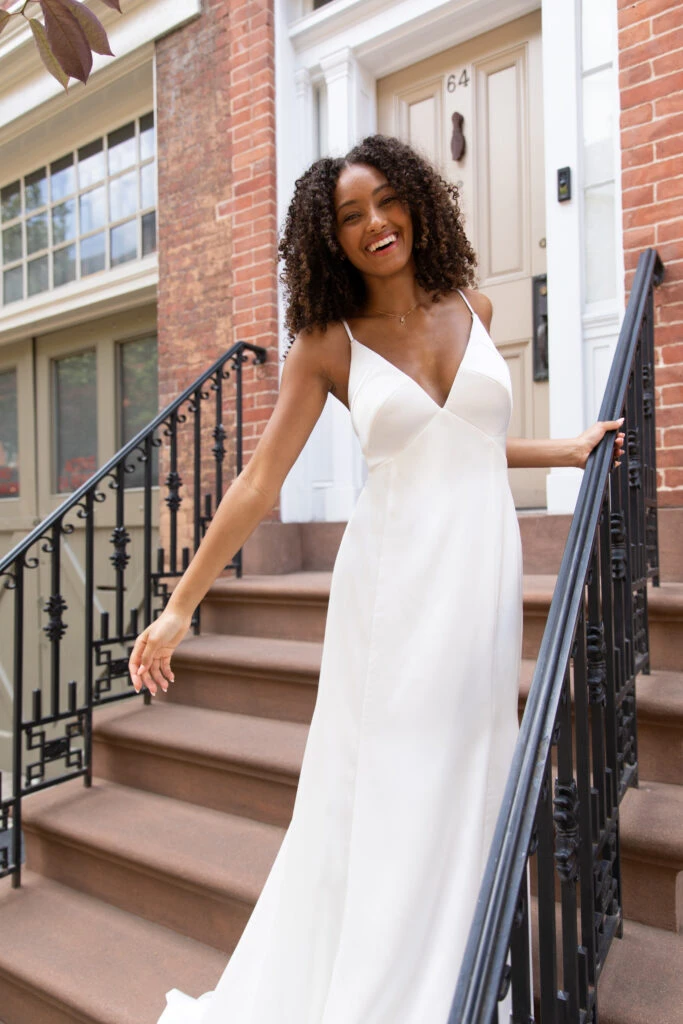 Bride wearing a simple wedding dress standing on steps