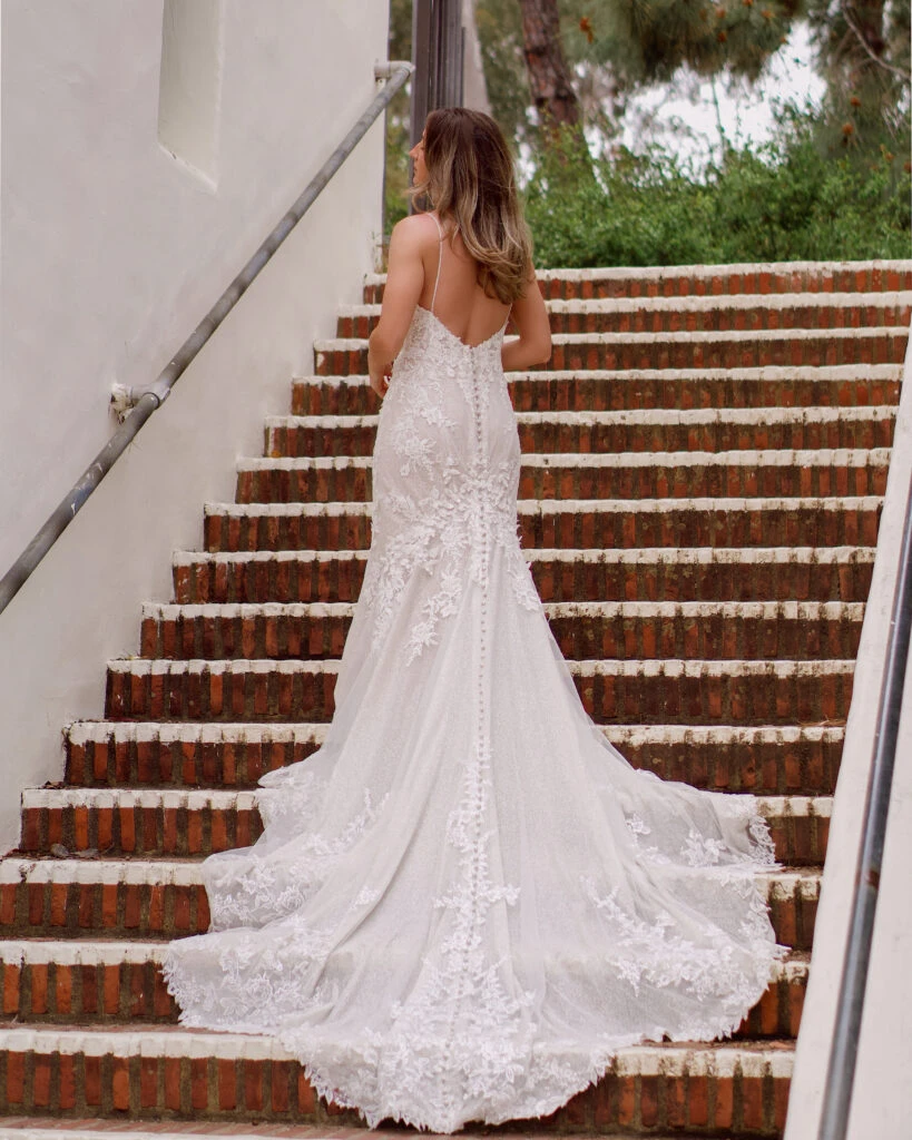 bride standing on a staircase wearing sparkly mermaid wedding dress