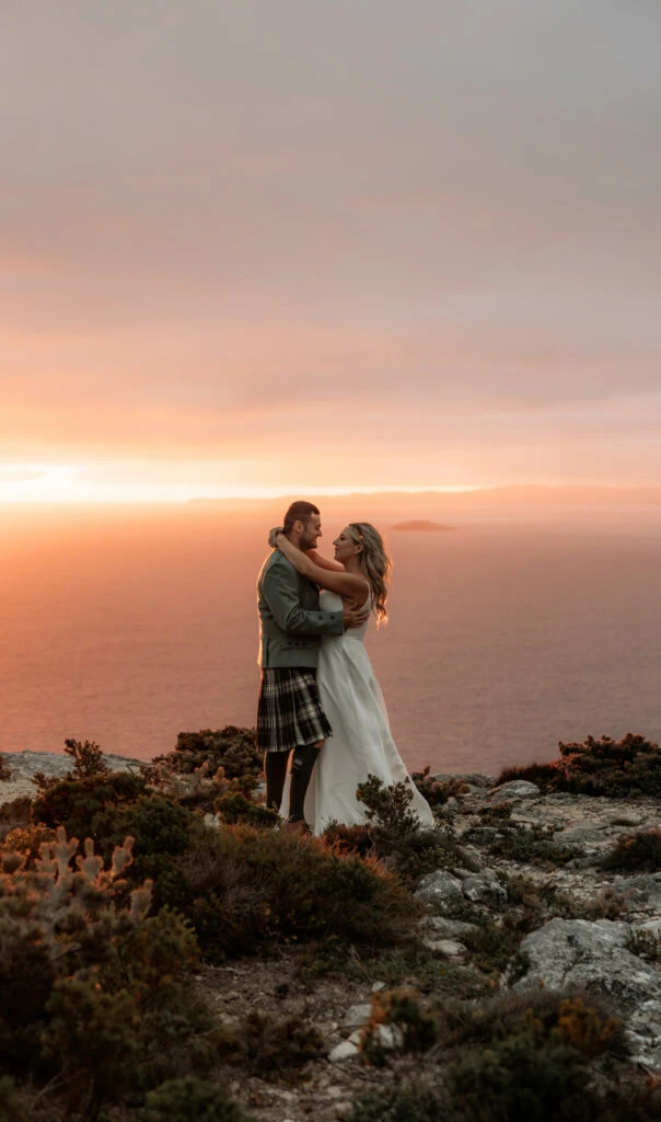 true bride danni and dean embracing on the cliffs over the sea - D3460 by Essense of Australia