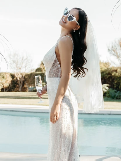 model leaning back in sparkling column wedding dress and heart sun glasses