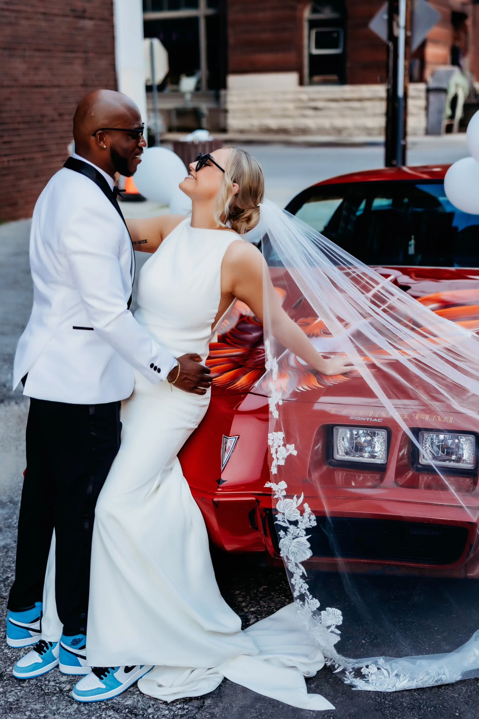 Bailee and Quanzee posing next to old car in matching sneakers