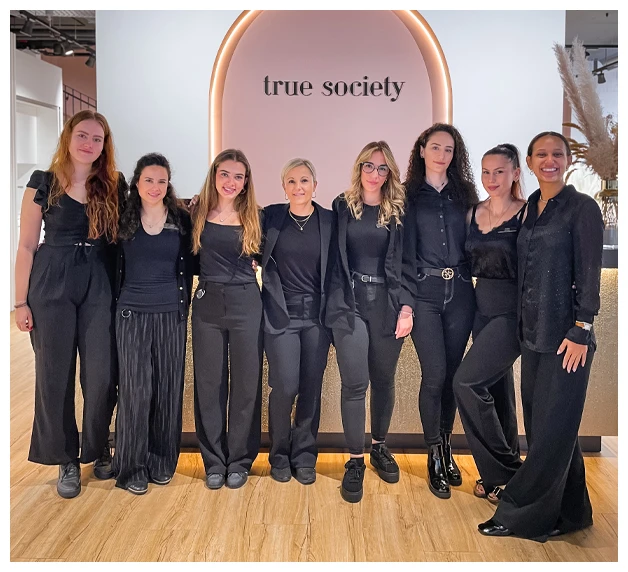 Zug True Society staff lined up at front dress wearing all black and smiling