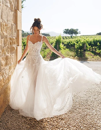 Bride wearing a etheral lace wedding dress twirling in a vineyard