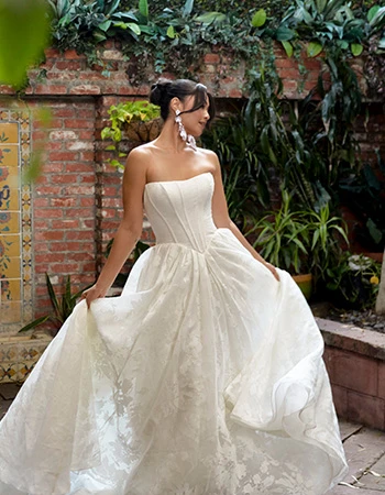 bride twirling around in a strapless lace drop waist ballgown