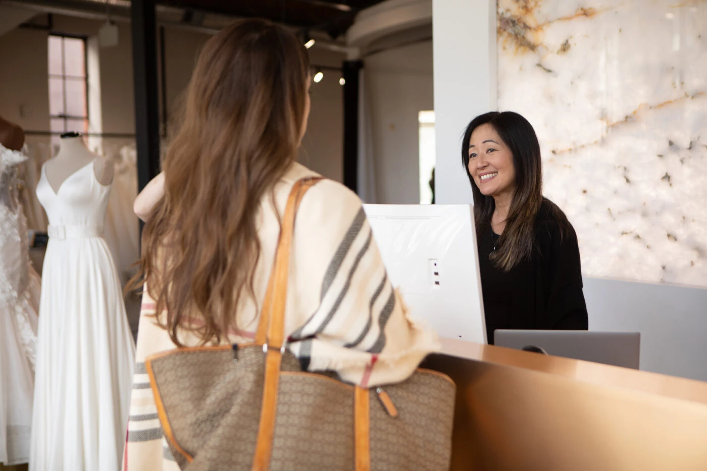 bride speaking with bridal stylist at desk