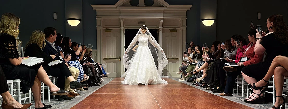 bridal model walking down the runway in a-line wedding dress and veil